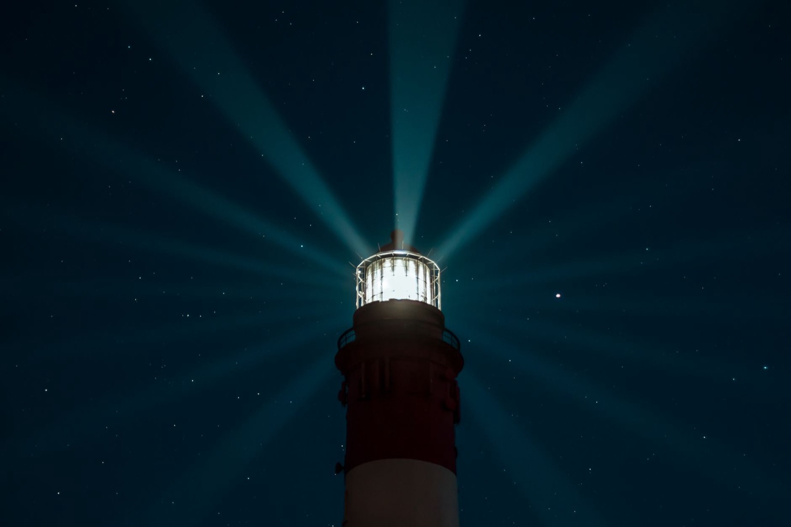 A lighthouse beam sweeping the night