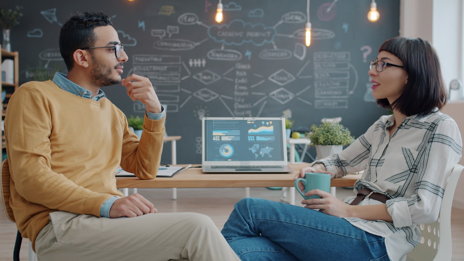 Two colleagues discussing work in an office